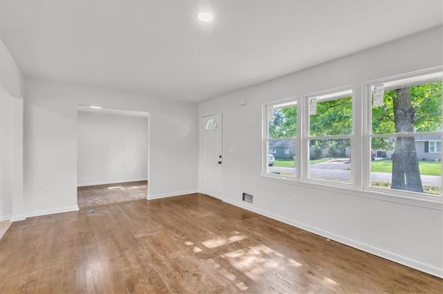12926 Virginia Ave, Kansas City, MO 64146 - unfurnished living room with plenty of natural light, wood finished floors, and baseboards