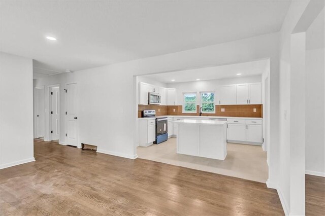 12926 Virginia Ave, Kansas City, MO 64146 - kitchen with appliances with stainless steel finishes, white cabinetry, decorative backsplash, a sink, and recessed lighting