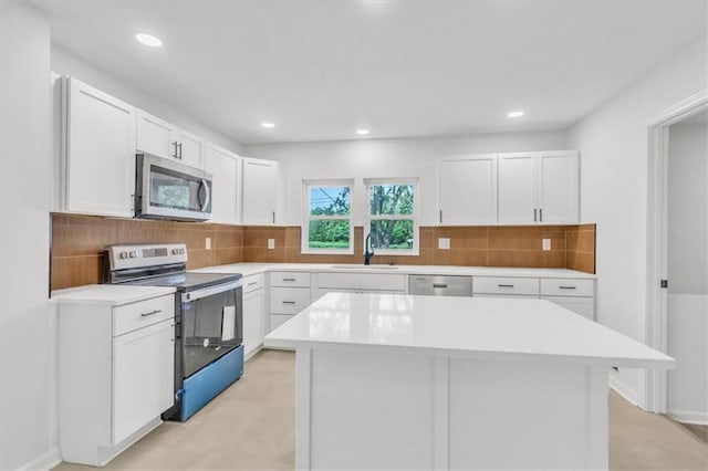 12926 Virginia Ave, Kansas City, MO 64146 - kitchen with appliances with stainless steel finishes, a sink, light countertops, white cabinetry, and decorative backsplash