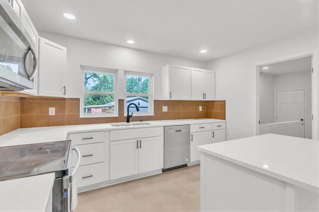12926 Virginia Ave, Kansas City, MO 64146 - kitchen with appliances with stainless steel finishes, a sink, white cabinets, decorative backsplash, and light countertops