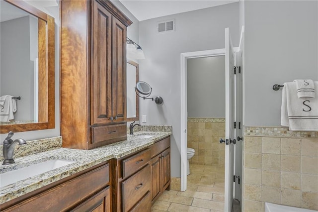 6522 W 133rd Ter, Leawood, KS 66209 - bathroom featuring double vanity and stone tile floors
