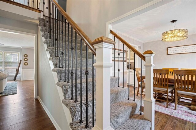 5901 W 158th St, Overland Park, KS 66223 - stairway featuring wood finished floors, a chandelier, and crown molding