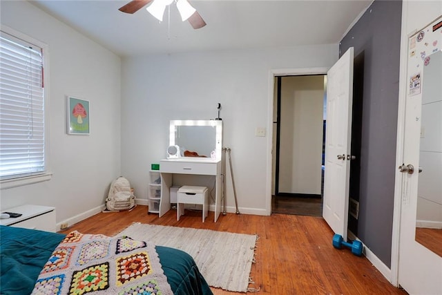 822 S Noland Rd, Independence, MO 64050 - bedroom featuring wood finished floors, multiple windows, a ceiling fan, and baseboards