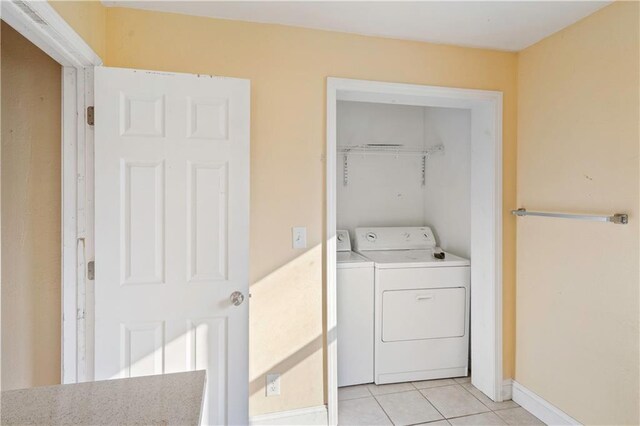 605 N Ardinger St, Hamilton, MO 64644 - laundry area featuring washer and dryer, light tile patterned floors, and baseboards