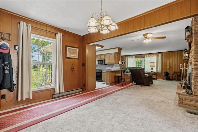 5201 Noland Rd, Kansas City, MO 64133 - living area featuring wood walls, light colored carpet, a chandelier, a baseboard radiator, and a ceiling fan