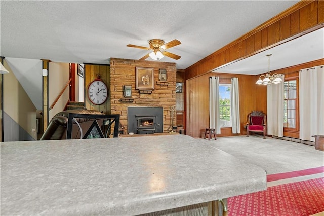 5201 Noland Rd, Kansas City, MO 64133 - dining area with ceiling fan, a chandelier, wood walls, carpet flooring, and stairs