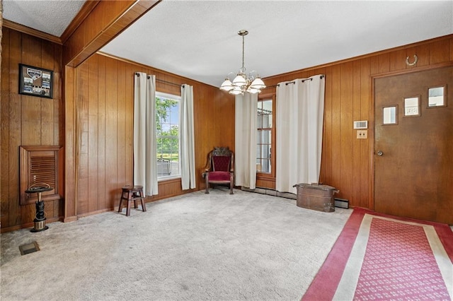 5201 Noland Rd, Kansas City, MO 64133 - foyer featuring wood walls, a chandelier, carpet, ornamental molding, and a textured ceiling