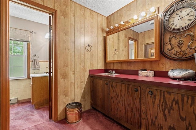 5201 Noland Rd, Kansas City, MO 64133 - bathroom featuring vanity, wood walls, a textured ceiling, and baseboard heating