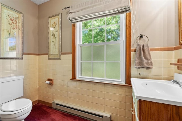 5201 Noland Rd, Kansas City, MO 64133 - half bath featuring baseboard heating, tile walls, vanity, and a wainscoted wall