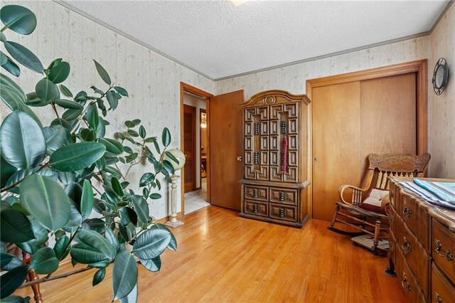 5201 Noland Rd, Kansas City, MO 64133 - sitting room with a textured ceiling, wood finished floors, and wallpapered walls