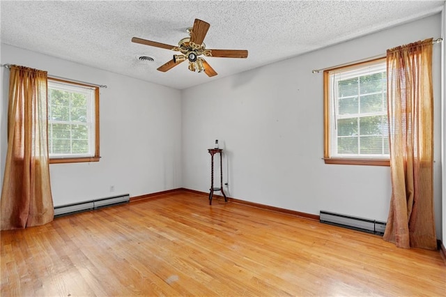 5201 Noland Rd, Kansas City, MO 64133 - empty room with baseboard heating, a baseboard heating unit, light wood-style flooring, ceiling fan, and a textured ceiling