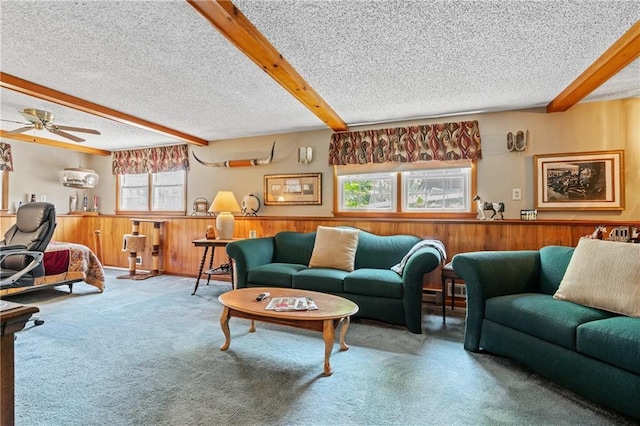 5201 Noland Rd, Kansas City, MO 64133 - carpeted living area with wood walls, wainscoting, beamed ceiling, ceiling fan, and a textured ceiling