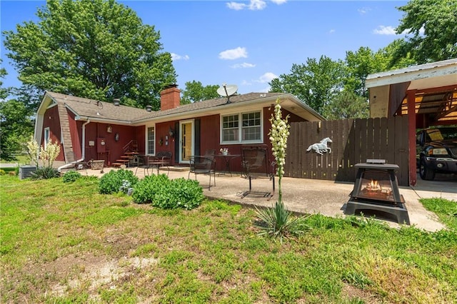 5201 Noland Rd, Kansas City, MO 64133 - view of front of home featuring a chimney, a patio, an outdoor fire pit, and entry steps