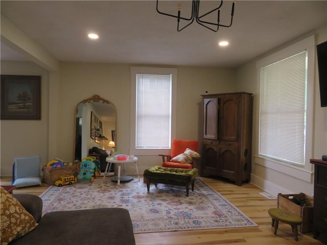 205 W Wea St, Paola, KS 66071 - living room with light wood-type flooring, a chandelier, recessed lighting, and arched walkways