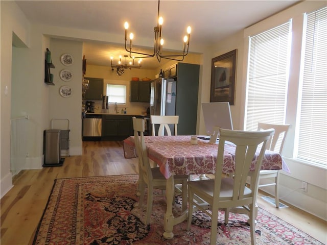 205 W Wea St, Paola, KS 66071 - dining area with radiator heating unit, a chandelier, and light wood finished floors
