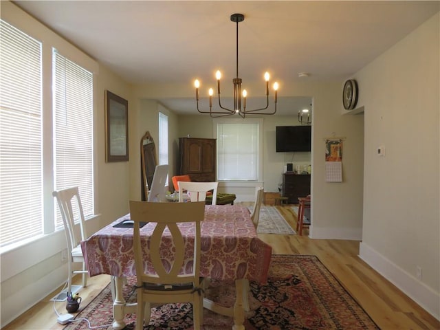 205 W Wea St, Paola, KS 66071 - dining room with a chandelier and light wood-type flooring