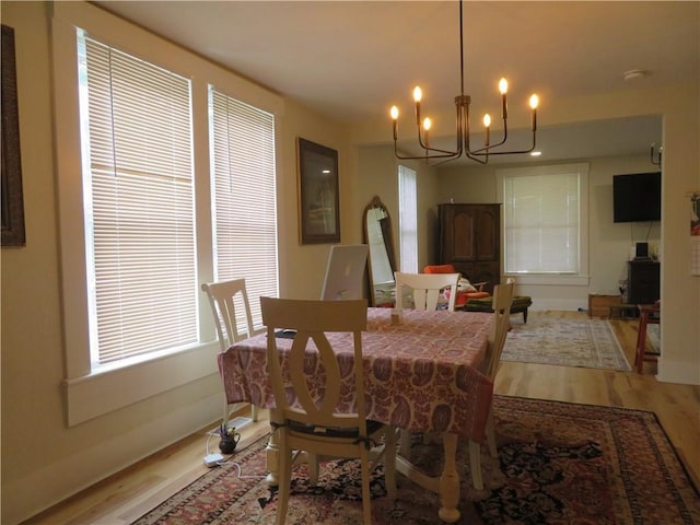 205 W Wea St, Paola, KS 66071 - dining space with wood finished floors and a chandelier