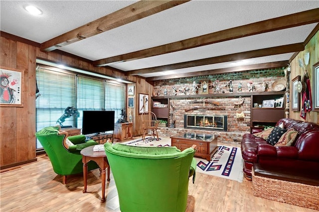 11814 W 149th St, Olathe, KS 66062 - living area featuring wood walls, wood finished floors, beam ceiling, a textured ceiling, and a fireplace