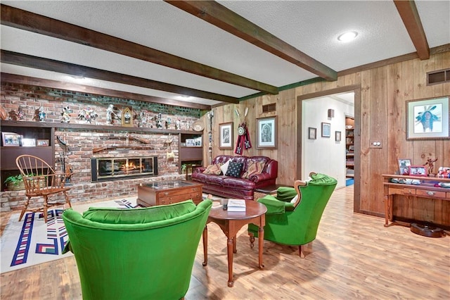 11814 W 149th St, Olathe, KS 66062 - living room with beamed ceiling, wood finished floors, a textured ceiling, a brick fireplace, and wood walls