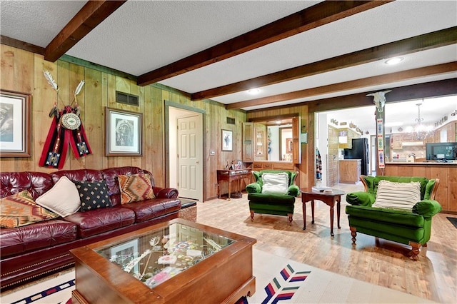 11814 W 149th St, Olathe, KS 66062 - living area with beamed ceiling, wooden walls, a baseboard heating unit, a textured ceiling, and wood finished floors