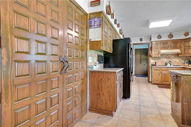 11814 W 149th St, Olathe, KS 66062 - kitchen with under cabinet range hood, freestanding refrigerator, decorative backsplash, light countertops, and light tile patterned floors