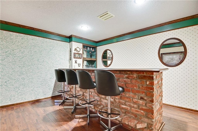 11814 W 149th St, Olathe, KS 66062 - indoor dry bar featuring wallpapered walls, crown molding, wood-type flooring, and a textured ceiling