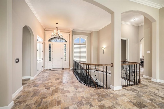 4512 NE Parks Summit Ter, Lees Summit, MO 64064 - foyer entrance with stone tile flooring, a chandelier, crown molding, and arched walkways