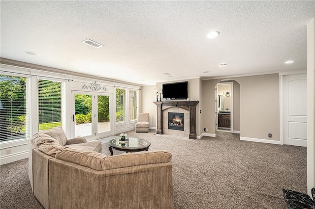 4512 NE Parks Summit Ter, Lees Summit, MO 64064 - living room featuring carpet flooring, a textured ceiling, arched walkways, recessed lighting, and a tiled fireplace