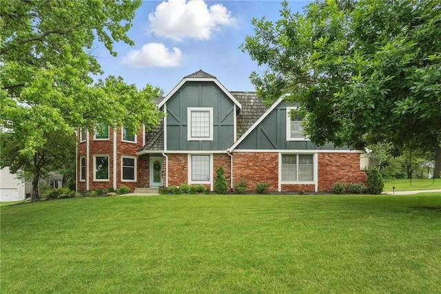 3632 NW Blue Jacket Dr, Lees Summit, MO 64064 - tudor-style house featuring a front lawn and brick siding