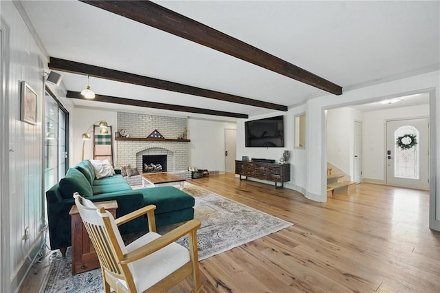 3632 NW Blue Jacket Dr, Lees Summit, MO 64064 - living area with stairs, light wood-style flooring, beam ceiling, baseboards, and a brick fireplace
