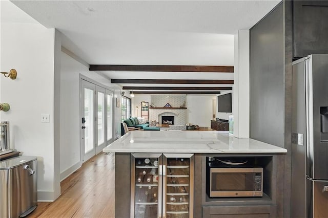 3632 NW Blue Jacket Dr, Lees Summit, MO 64064 - bar with stainless steel appliances, beverage cooler, light wood-style flooring, beamed ceiling, and a fireplace