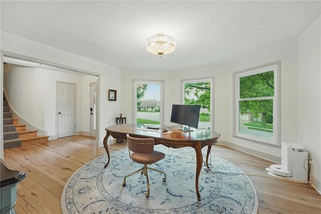 3632 NW Blue Jacket Dr, Lees Summit, MO 64064 - office area featuring light wood finished floors, baseboards, and a textured ceiling
