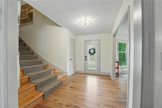 3632 NW Blue Jacket Dr, Lees Summit, MO 64064 - foyer entrance featuring stairway, wood-type flooring, a textured ceiling, and baseboards