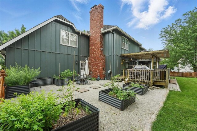3632 NW Blue Jacket Dr, Lees Summit, MO 64064 - back of house featuring a garden, board and batten siding, a chimney, a pergola, and a wooden deck