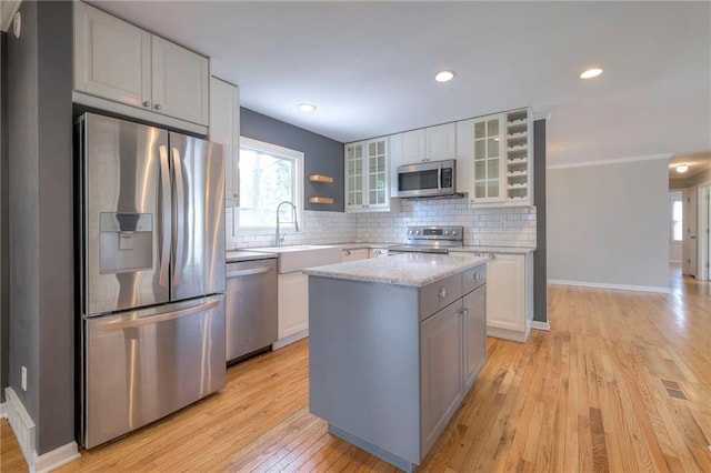 5917 W 101st Ter, Overland Park, KS 66207 - kitchen with appliances with stainless steel finishes, light wood-style floors, tasteful backsplash, healthy amount of natural light, and recessed lighting
