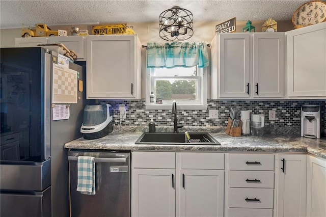 302 W 4th St, Waverly, KS 66871 - kitchen featuring stainless steel appliances, a sink, a textured ceiling, decorative backsplash, and white cabinets