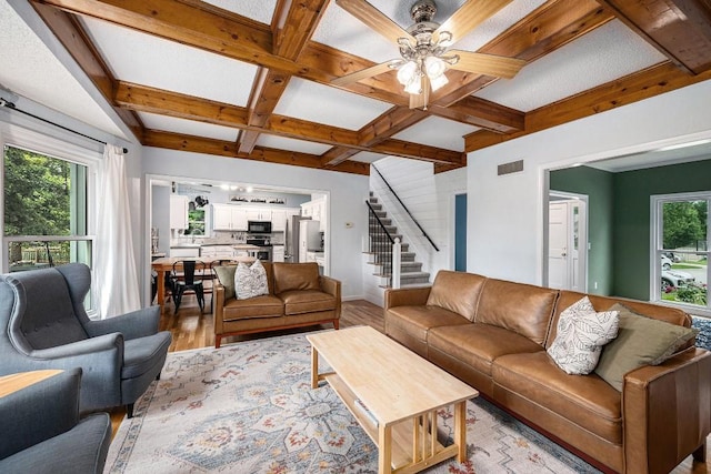 11601 Conser St, Overland Park, KS 66210 - living area featuring coffered ceiling, light wood-style floors, stairway, beam ceiling, and ceiling fan