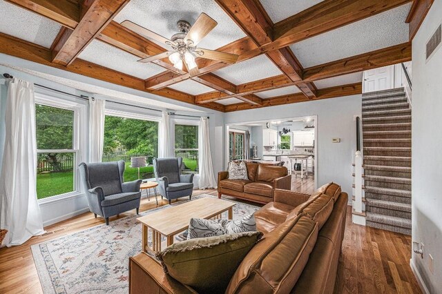 11601 Conser St, Overland Park, KS 66210 - living area with coffered ceiling, stairs, a ceiling fan, light wood-style flooring, and beamed ceiling