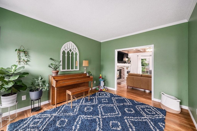 11601 Conser St, Overland Park, KS 66210 - sitting room featuring ornamental molding, wood finished floors, baseboards, a brick fireplace, and a textured ceiling