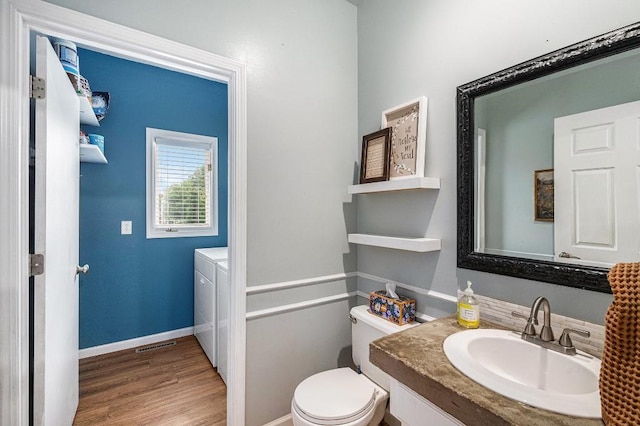 11601 Conser St, Overland Park, KS 66210 - bathroom featuring vanity, wood finished floors, toilet, washing machine and clothes dryer, and baseboards