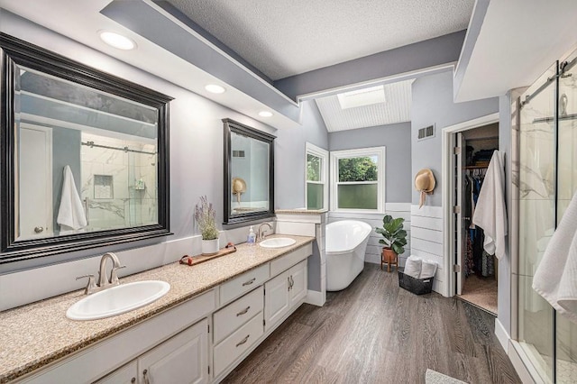 11601 Conser St, Overland Park, KS 66210 - bathroom with a stall shower, wood finished floors, double vanity, a spacious closet, and a freestanding bath