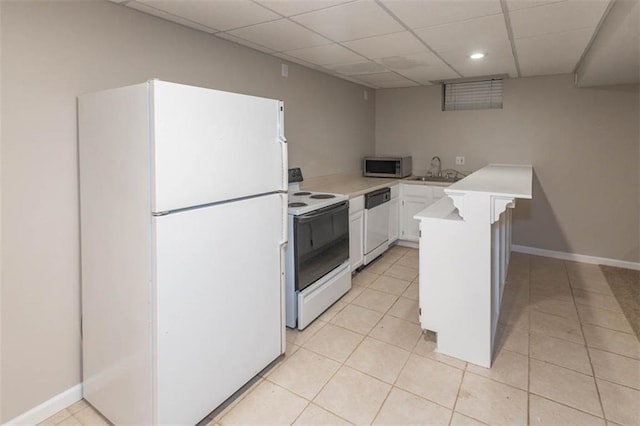 7503 N Lewis Ave, Kansas City, MO 64158 - kitchen featuring white appliances, a paneled ceiling, light countertops, white cabinetry, and light tile patterned floors