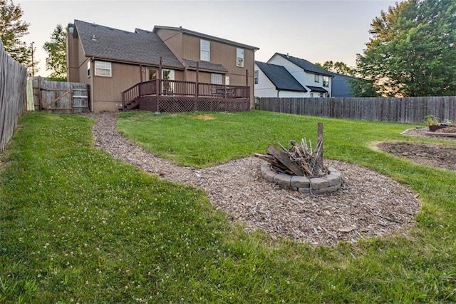 7503 N Lewis Ave, Kansas City, MO 64158 - fenced backyard with a wooden deck, a fire pit, and a gate
