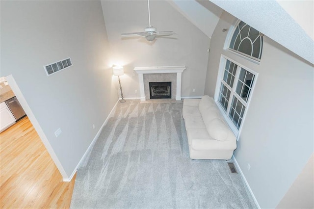 7503 N Lewis Ave, Kansas City, MO 64158 - unfurnished living room with ceiling fan, a fireplace, high vaulted ceiling, and carpet floors