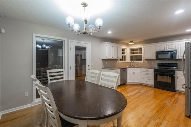 7503 N Lewis Ave, Kansas City, MO 64158 - dining area featuring a chandelier, light wood-style flooring, recessed lighting, and a textured ceiling