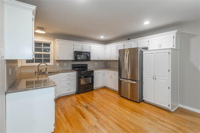 7503 N Lewis Ave, Kansas City, MO 64158 - kitchen with black appliances, light wood-style flooring, white cabinetry, decorative backsplash, and stone counters