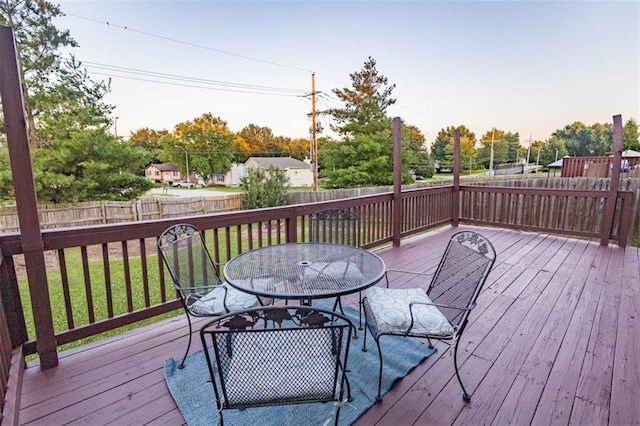 7503 N Lewis Ave, Kansas City, MO 64158 - wooden terrace with a fenced backyard, outdoor dining space, and view of wooded area