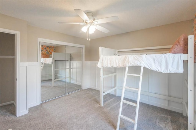 7503 N Lewis Ave, Kansas City, MO 64158 - unfurnished bedroom with carpet floors, a closet, a wainscoted wall, ceiling fan, and a decorative wall