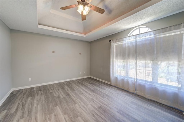 610 SE Joel Ave, Lees Summit, MO 64063 - empty room featuring wood finished floors, ceiling fan, and a raised ceiling