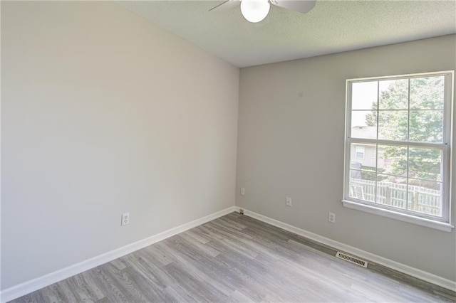 610 SE Joel Ave, Lees Summit, MO 64063 - empty room featuring a ceiling fan, plenty of natural light, wood finished floors, and a textured ceiling